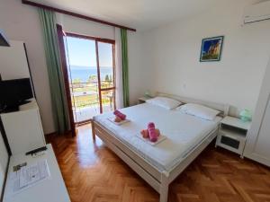 a bedroom with a bed and a large window at Apartments Slaven in Podgora