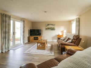a living room with a couch and a tv at Bramley Cottage in Clacton-on-Sea