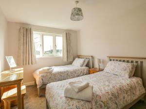 a bedroom with two beds and a window at Bramley Cottage in Clacton-on-Sea