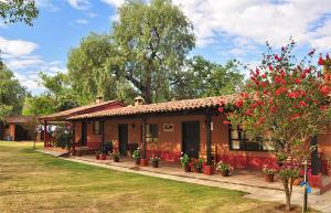 ein kleines Haus mit roten Blumen davor in der Unterkunft Villa Patzcuaro Garden Hotel in Pátzcuaro