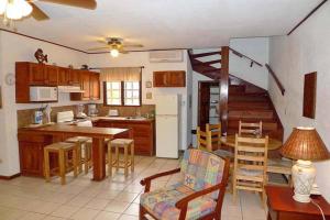a kitchen and dining room with a spiral staircase at Centric, clean, safe, with pool & monkey visitors in Tamarindo
