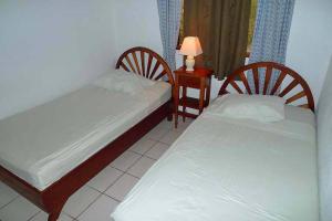 a bedroom with two beds and a table with a lamp at Centric, clean, safe, with pool & monkey visitors in Tamarindo +9 photos