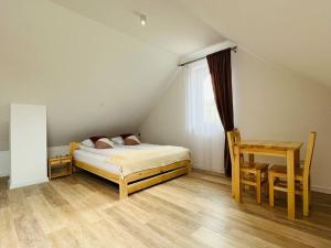 a bedroom with a bed and a table and a chair at Apartament Primula 2 in Jaworki
