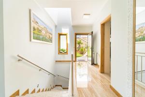 una escalera en una casa con paredes blancas y suelo de madera en Casa de Eiró by House and People, en Barcelos