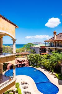 a view of a resort with a swimming pool and the ocean at Family Setting, Big Pool Beach Facing In Towns in Tamarindo