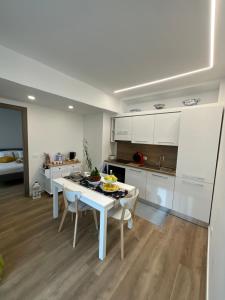 a white kitchen with a white table and chairs at Villa Fontana in Celle Ligure +1 photo