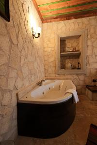 eine Badewanne im Bad mit einer Steinmauer in der Unterkunft By Yüksel Cave in Ürgüp