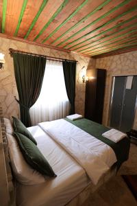 ein großes Bett in einem Zimmer mit Holzdecke in der Unterkunft By Yüksel Cave in Ürgüp