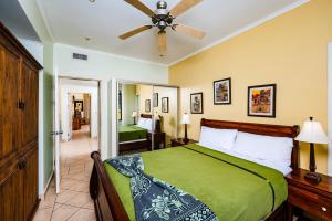 a bedroom with a green bed with a ceiling fan at Family Setting, Big Pool Beach Facing In Towns in Tamarindo