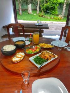 uma mesa de madeira com comida e bebidas em Villa do Lago em Poços de Caldas