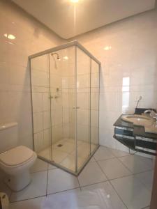 ein Badezimmer mit Dusche, Toilette und Waschbecken in der Unterkunft Villa do Lago in Poços de Caldas