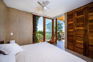 ein Schlafzimmer mit einem Bett und einem großen Fenster in der Unterkunft Spacious & Serene With Partial Ocean & Jungle View in Tamarindo + 17 Fotos