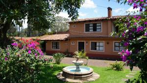 ein Haus mit einem Brunnen vor einem Hof in der Unterkunft Villa Patzcuaro Garden Hotel in Pátzcuaro