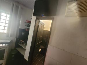 eine kleine Küche mit einer Tür, die zu einem Zimmer führt in der Unterkunft Hospedaria cmc unidade 03 Com Estacionamento in Riacho Fundo + 20 Fotos