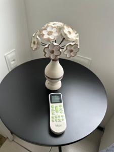 a table with a calculator and a vase with flowers at Atlantic Ocean Residence in Fortaleza