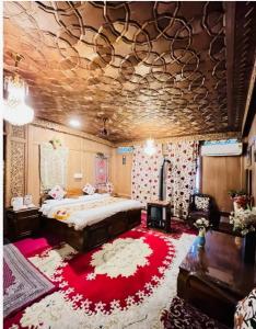 斯利那加的住宿－Lakes Crown Group Of Houseboats，一间卧室配有一张大床和红色地毯。