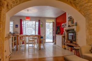 une cuisine et un salon avec une table et des chaises dans l'établissement La maison du Chateau, à Saint-Paul-Trois-Châteaux