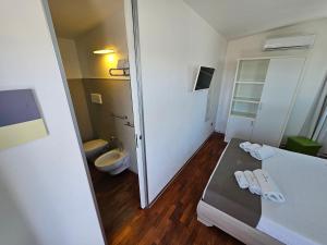 Habitación pequeña con cama y baño. en B&B White con Parcheggio Privato, en Porto Cesareo