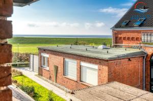 a brick building with a view of the ocean at Landhaus Gertrude 105 - Wohnung Wattenmeer in Juist