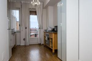 cocina con nevera, mesa y ventana en Home Sweet Home en Milán