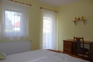 Un dormitorio con una cama y una cómoda y dos ventanas. en Otto Apartment, en Harkány
