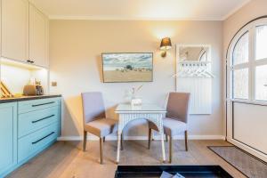 a kitchen with a table and chairs in a room at Appartement Hamburg in Westerland +22 photos