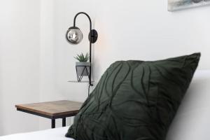uma almofada verde sentada numa cama ao lado de uma mesa em Three Bedroom Home in Myddle em Myddle