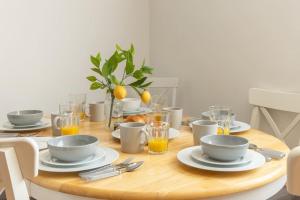 uma mesa de madeira com pratos e copos de sumo de laranja em Three Bedroom Home in Myddle em Myddle