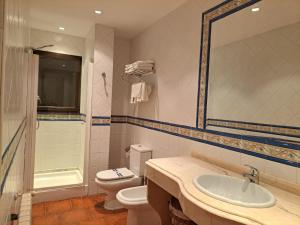 a bathroom with a sink and a toilet and a mirror at Estudio Azul Paraíso in Llanes