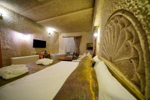 a bedroom with a large bed in a room at Cave Hotel Saksagan in Göreme