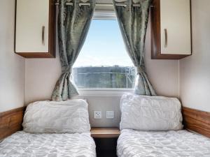 two beds in a small room with a window at Sea View 59 - Uk45586 in Mainsriddle