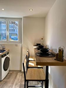 a kitchen with a table with black bowls on it at Le Cocon de la Gare de Grenoble in Grenoble +12 photos