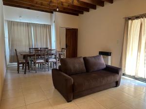 sala de estar con sofá, mesa y sillas en Casa tranquila y cómoda, muy cerca del centro en Tunuyán