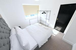 a bedroom with a white bed and a glass shower at Vibrant 3BD home with great links to the city in London