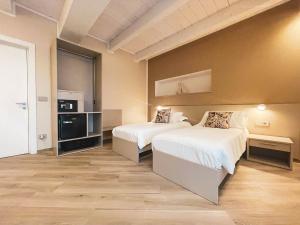 una camera d'albergo con due letti e una tv di GIO' HOUSE a Fossano