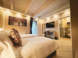 1 dormitorio con 2 camas blancas y TV en GIO' HOUSE, en Fossano