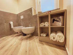 bagno con lavandino, servizi igienici e asciugamani di GIO' HOUSE a Fossano Altre 37 foto