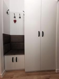 a room with white cabinets with black handles at ALDIRA Studio Arena Nationala in Bucharest