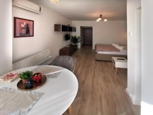 - un salon avec une table blanche et un lit dans l'établissement ALDIRA Studio Arena Nationala, à Bucarest