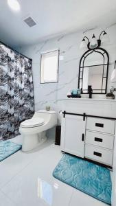 uma casa de banho com um WC, um lavatório e um espelho. em Conociendo Miami em Hialeah