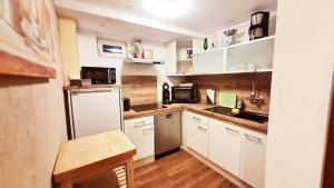 cocina con armarios blancos y nevera blanca en Apartment Neuweiher, en Daisendorf