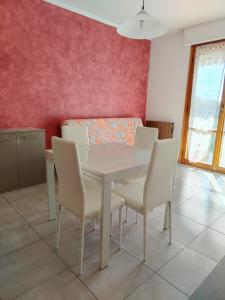 a dining room with a white table and chairs at Casa Agave in Ventimiglia