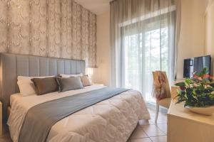 a bedroom with a large bed and a window at Hotel Athena in Cervia