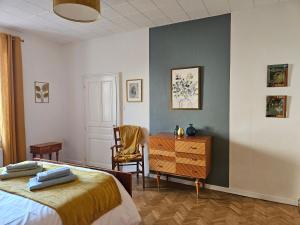 um quarto com 2 camas, uma cómoda e uma cadeira em Les camélias em Selles-sur-Cher