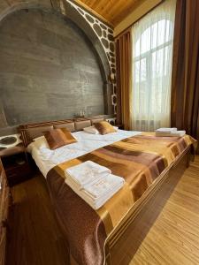 a large bed in a room with a large window at Kirch Hotel & Restaurant in Goris