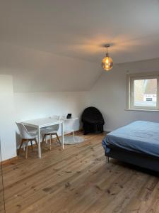 ein Schlafzimmer mit einem Tisch, Stühlen und einem Bett in der Unterkunft mooie vakantiewoning nabij Brugge in Damme