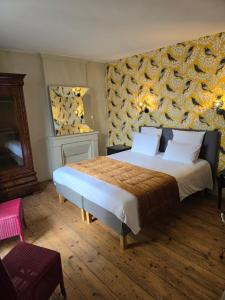 1 dormitorio con cama extragrande y pared en Au Loup Historic Apartments en Bayeux