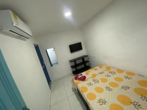 Dormitorio pequeño con cama y TV en Hotel 7 en Cúcuta