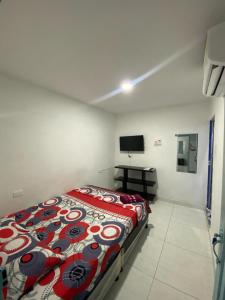 1 dormitorio con 1 cama y TV en Hotel 7 en Cúcuta