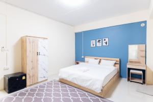 - une chambre avec un lit et un mur bleu dans l'établissement Hatyai Humble Home 03, à Hat Yai